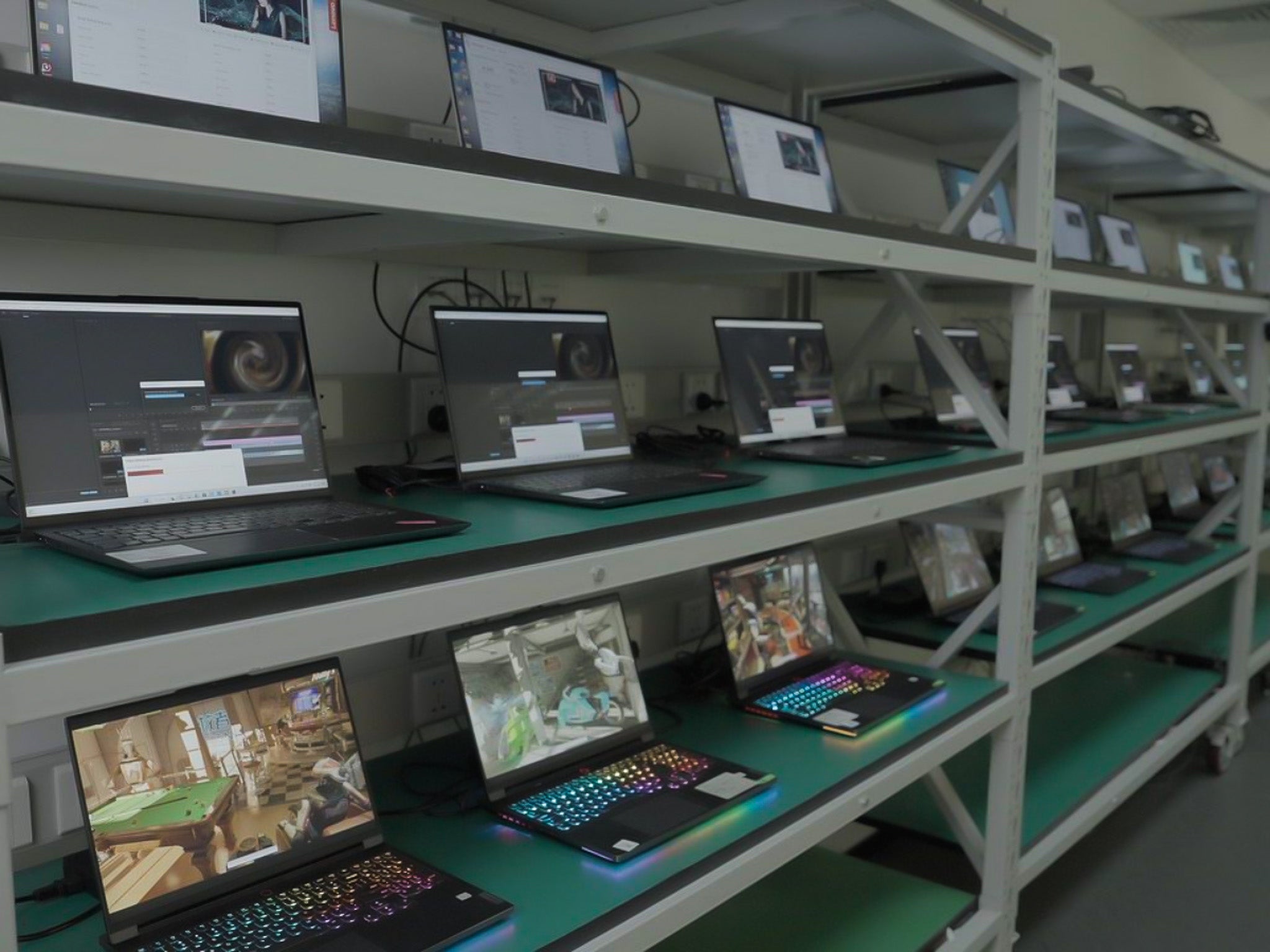 Many laptops sitting on a shelf during testing