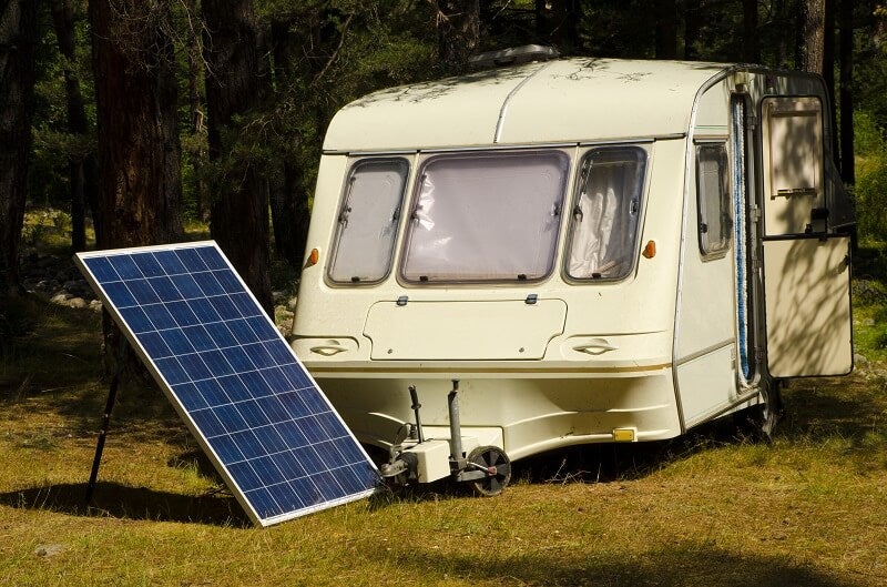Older camper sits to the side of a large solar array