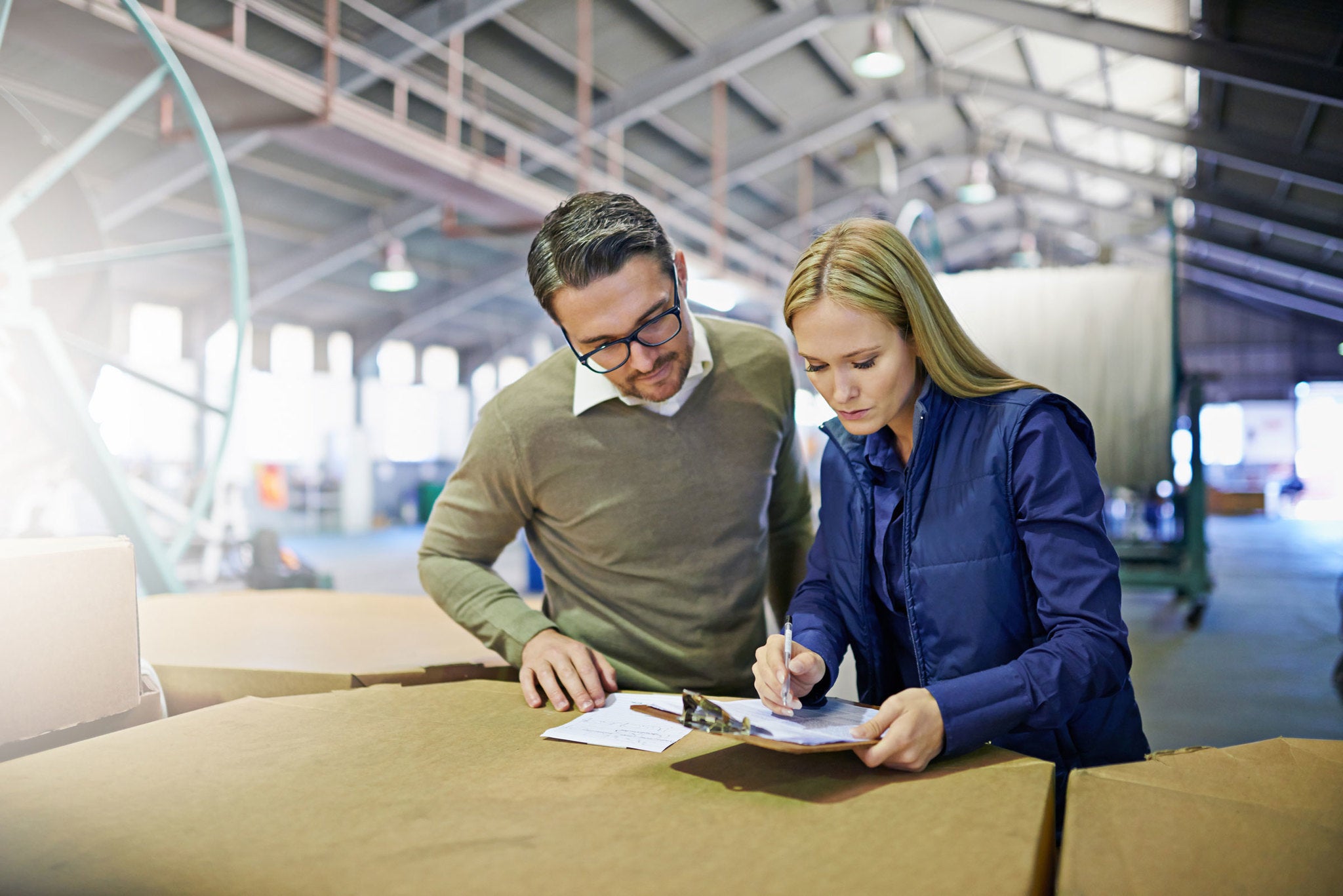 A Man and a woman look at something together in workplace