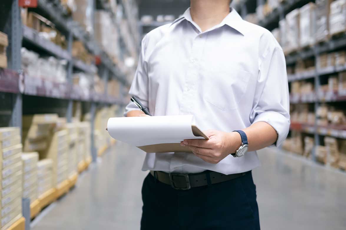 Man checking items on a clipboard in a warehouse