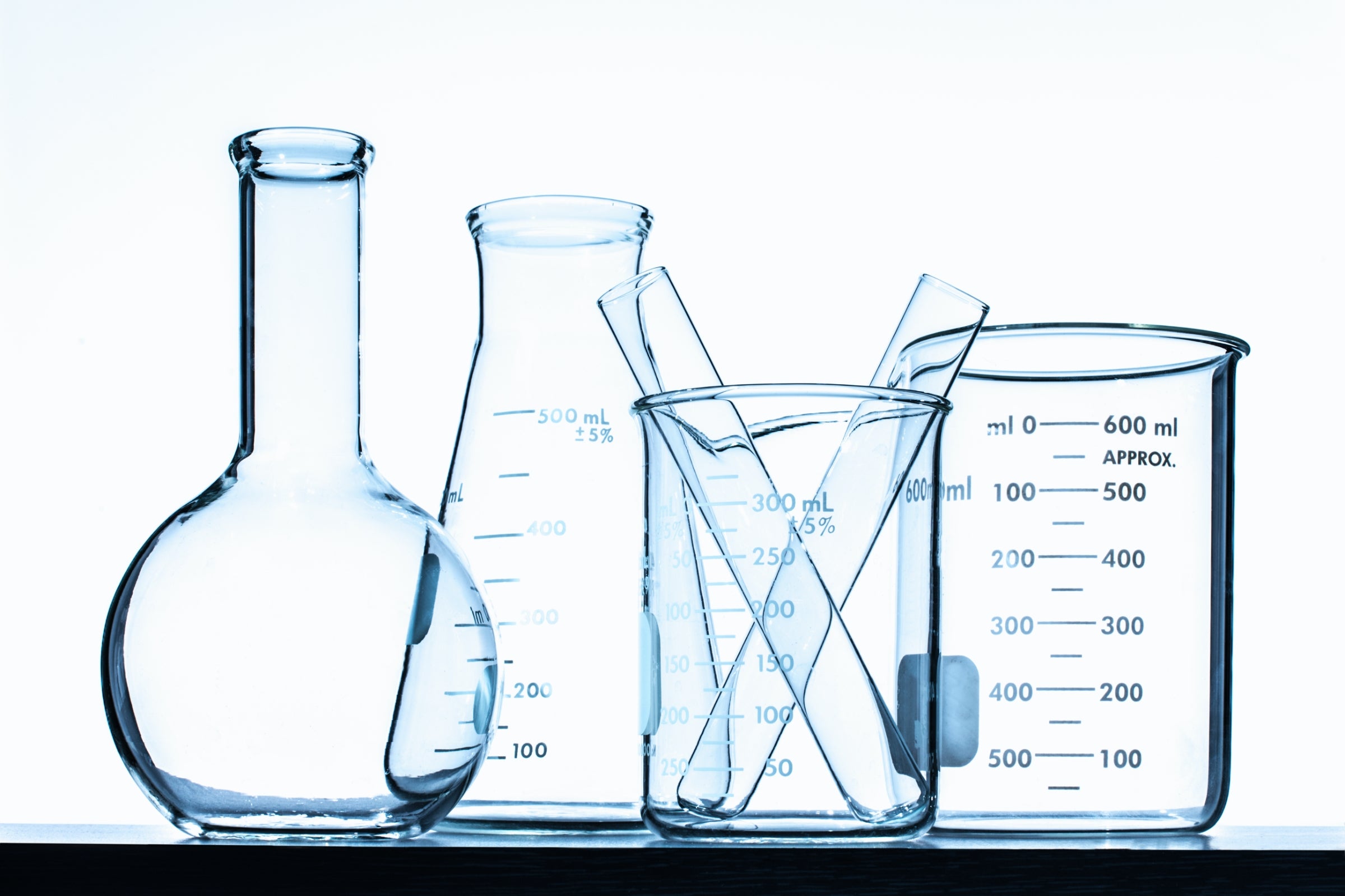 Glass beakers in front of a white wall