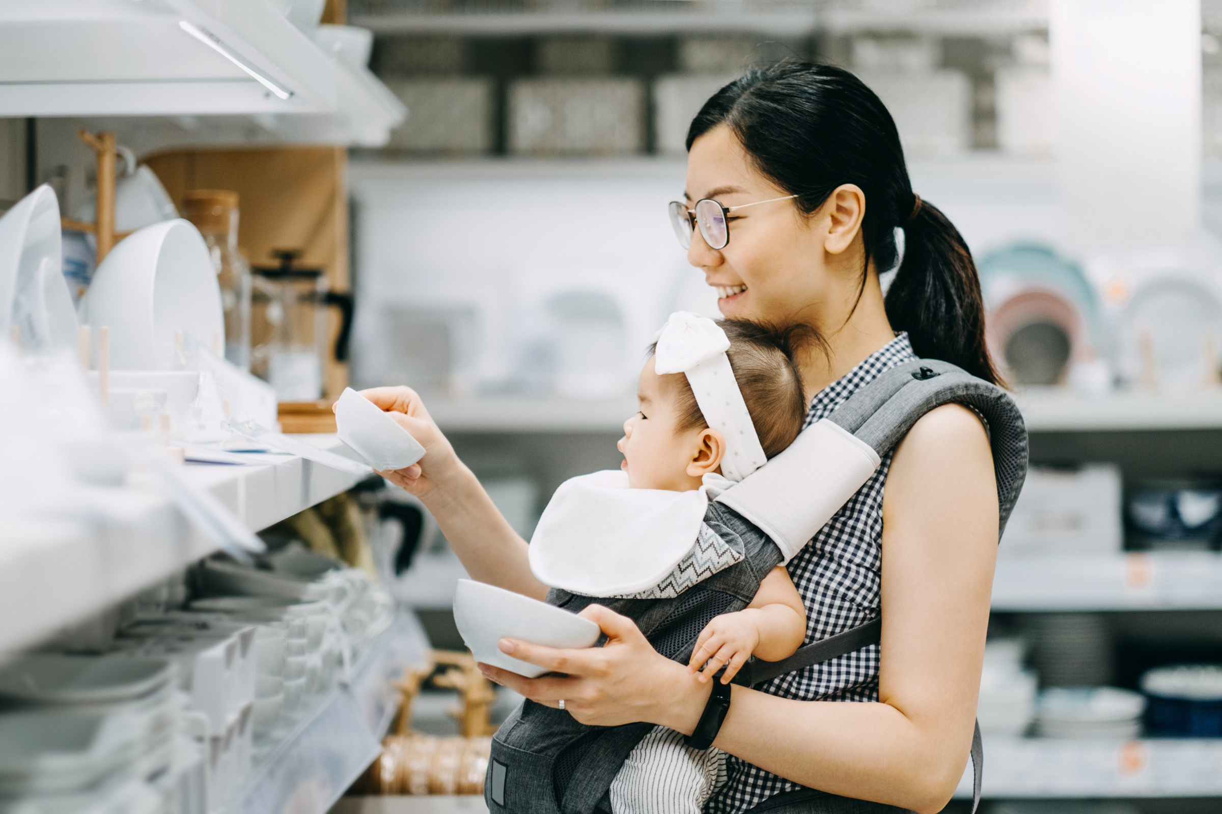 Woman shopping for dishes with her baby