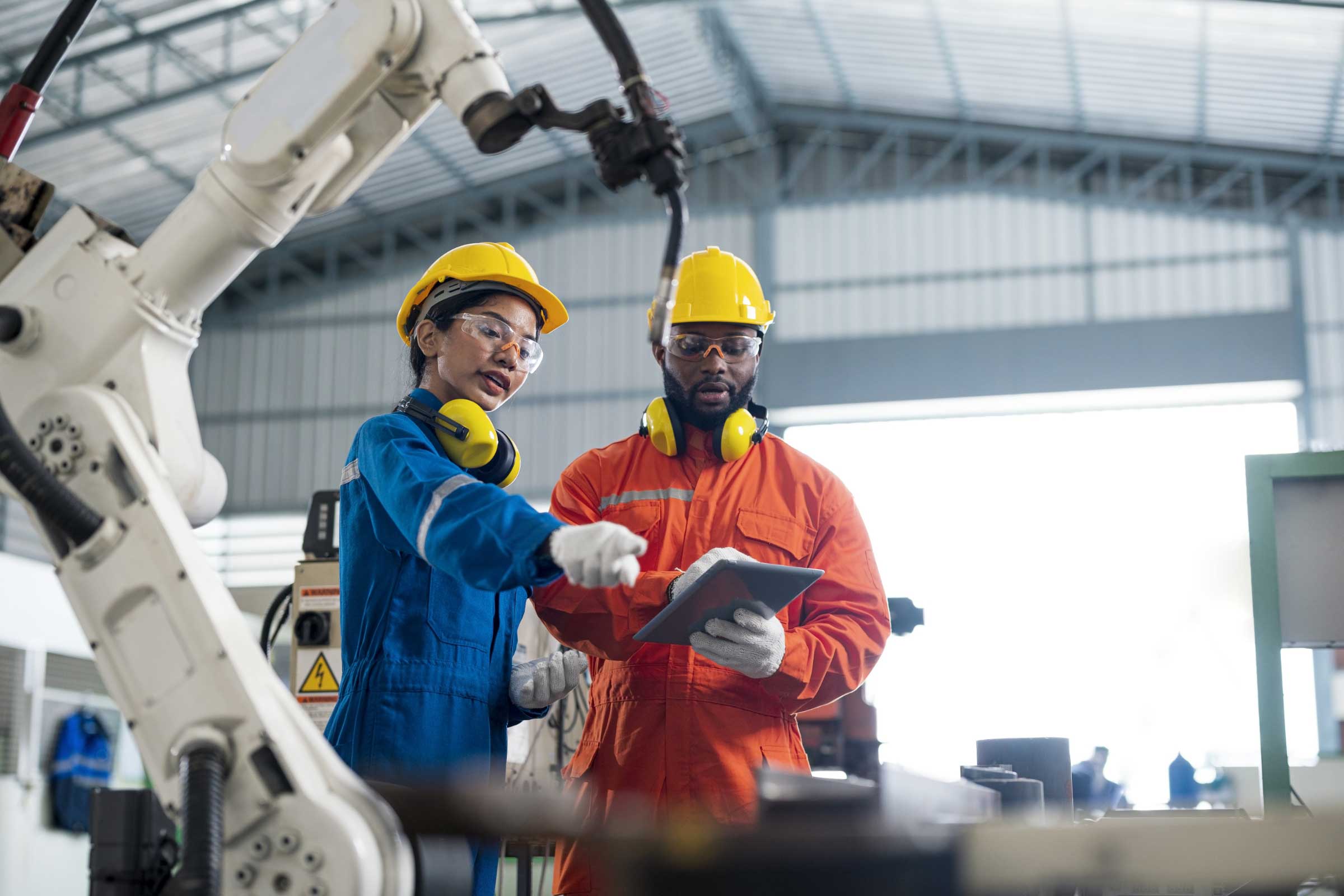 Man and woman in protective gear discussing content on a tablet 