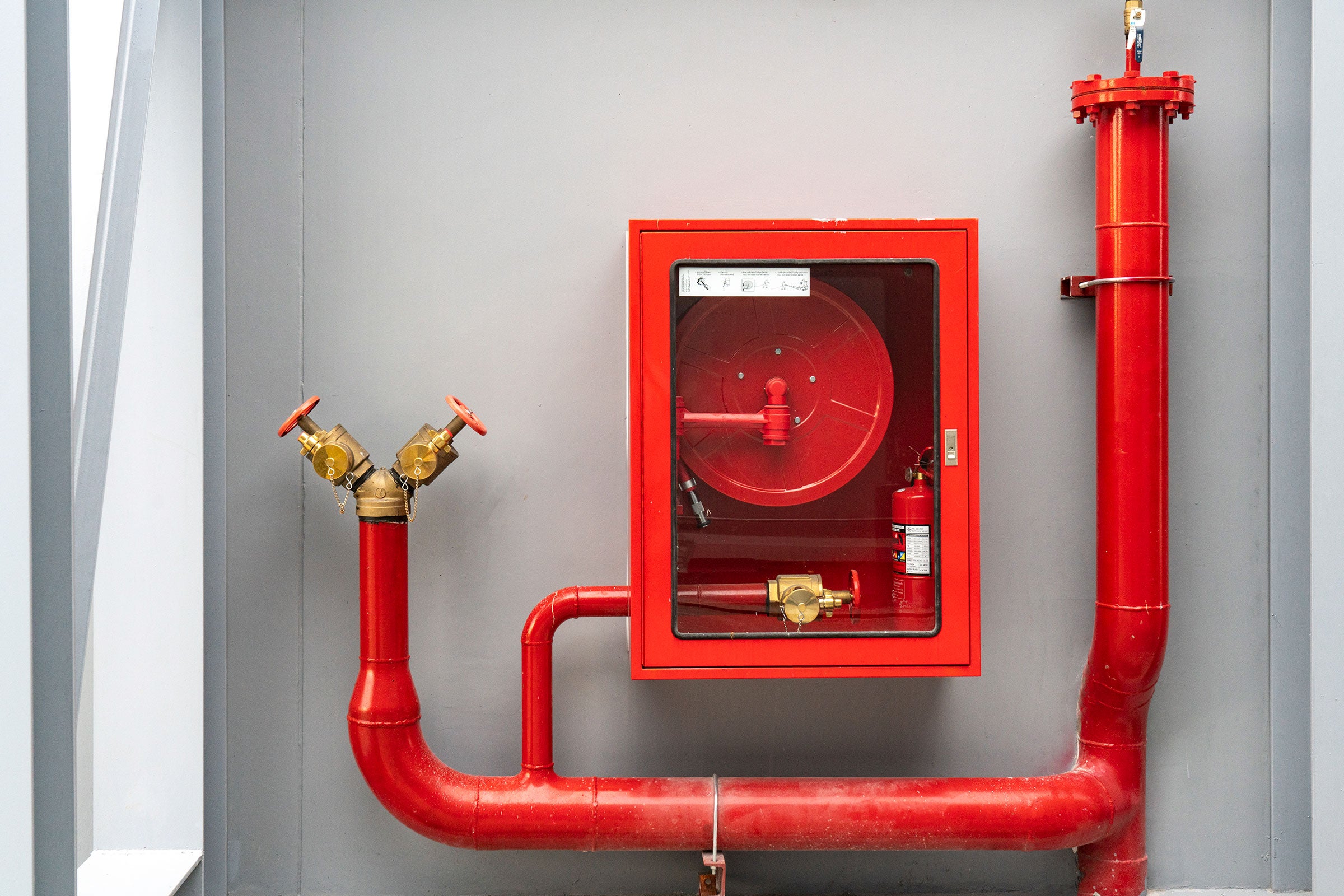 Fire extinguisher and fire hose reel in hotel corridor