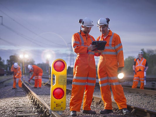 workers wearing protective equipment and working on railway