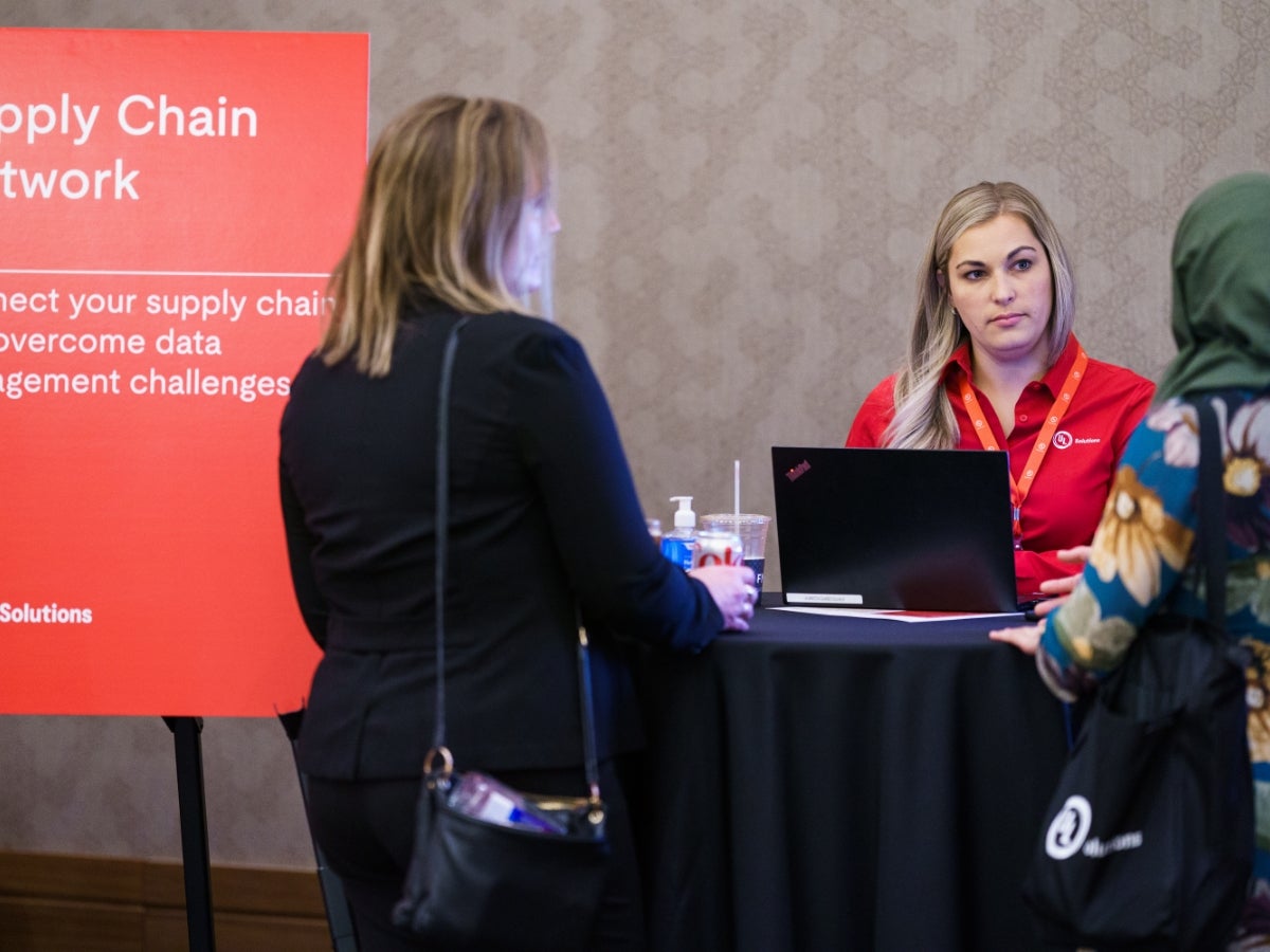 UL Solutions employee in front of a computer talking with two others