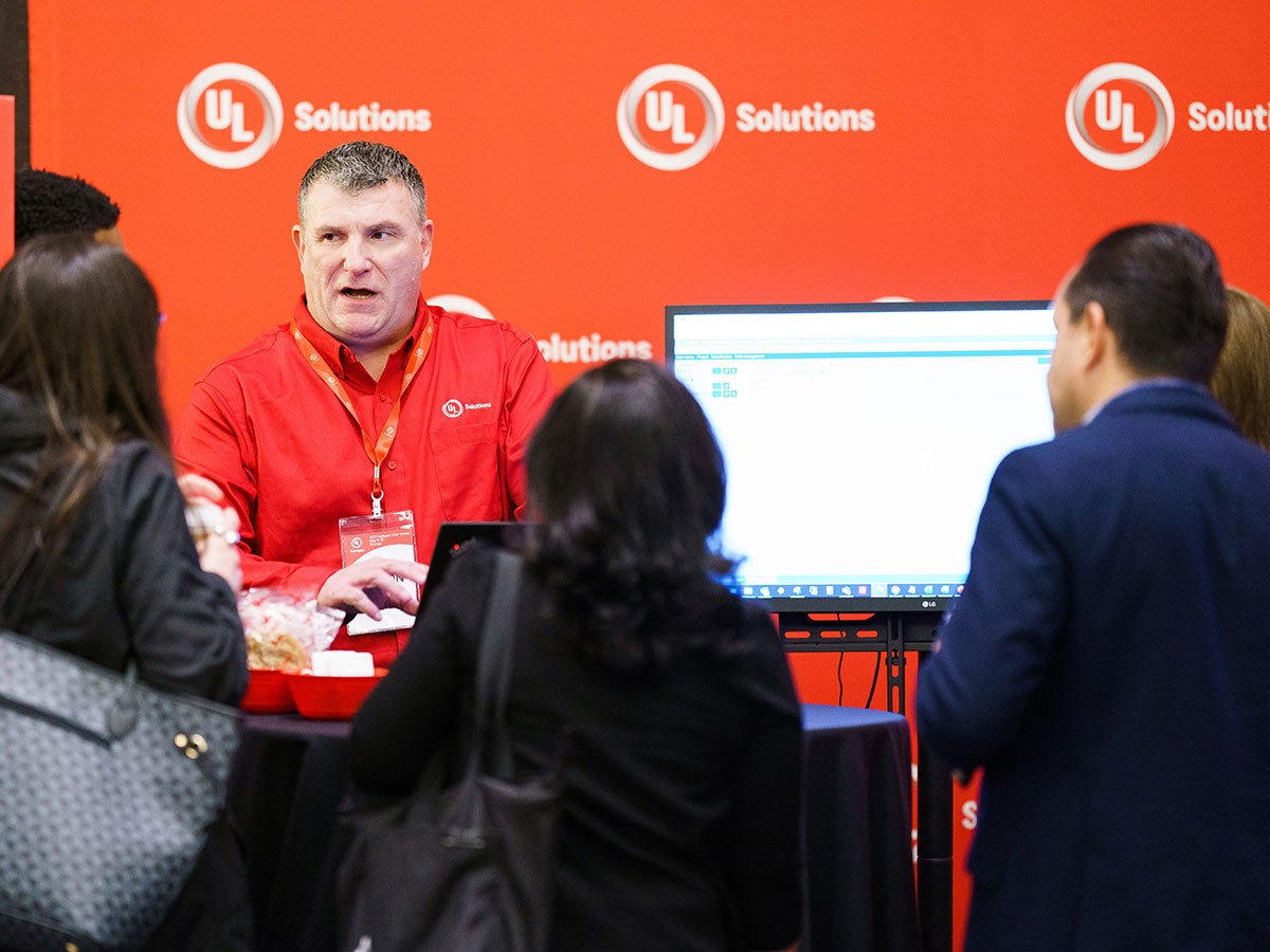 UL Solutions employee talking to a small group of people in front of a computer screen