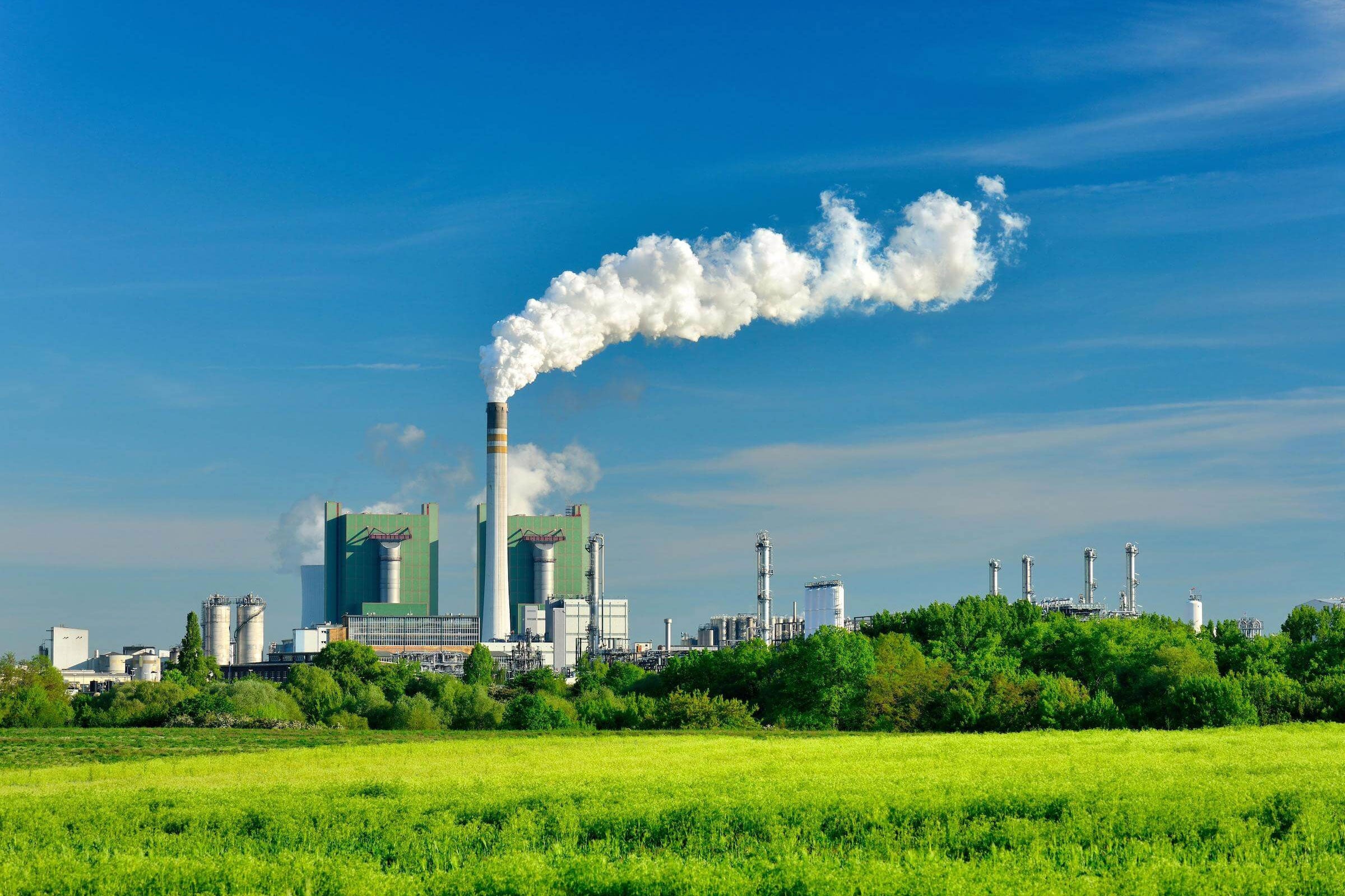 Steaming ignite-fired power plant in a green landscape