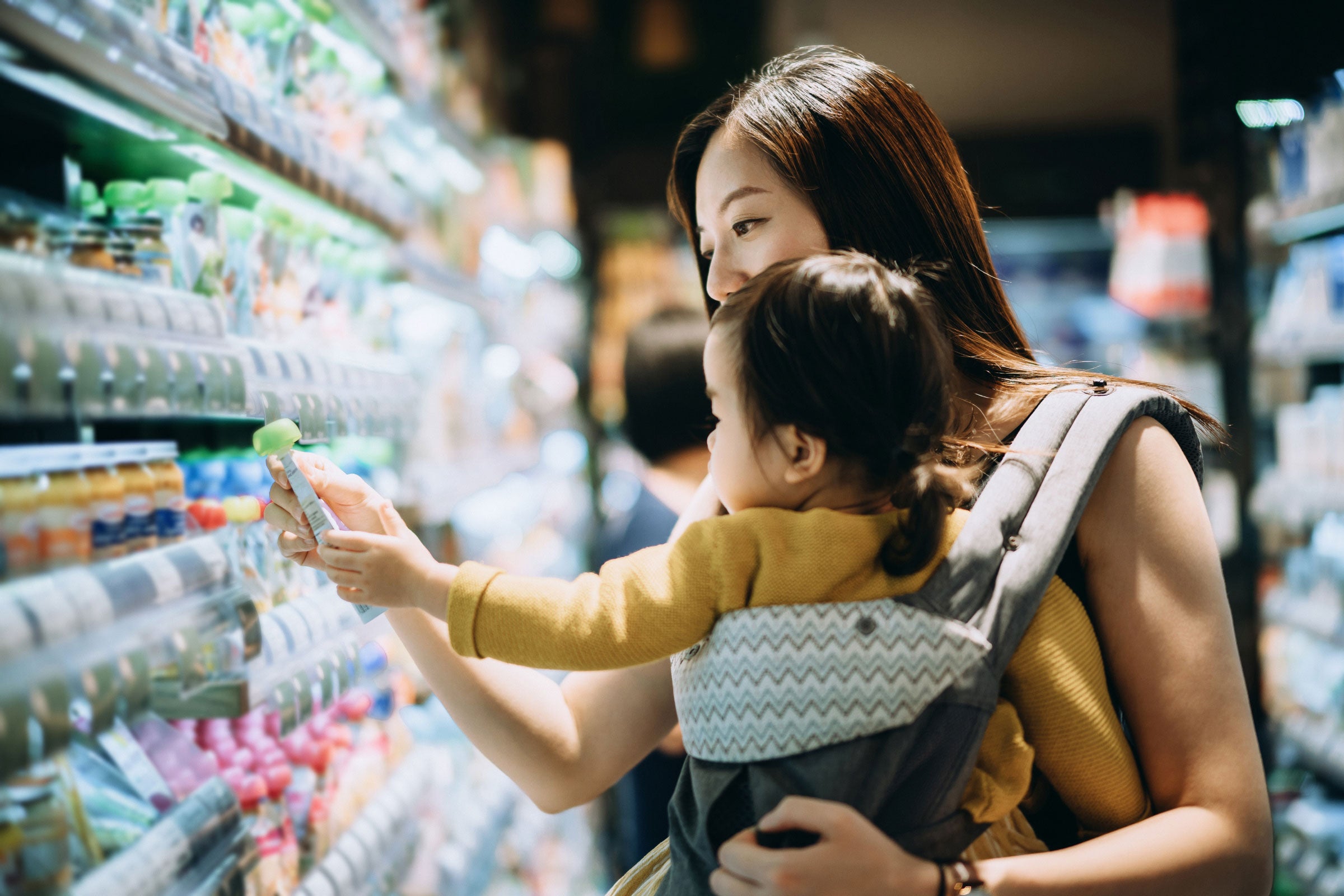 A mother shopping while carrying her baby