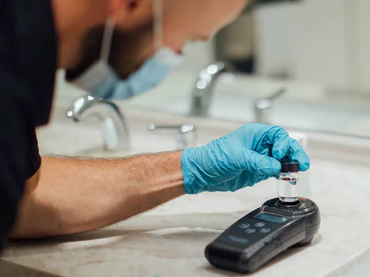 Person analyzing a water sample in a bathroom