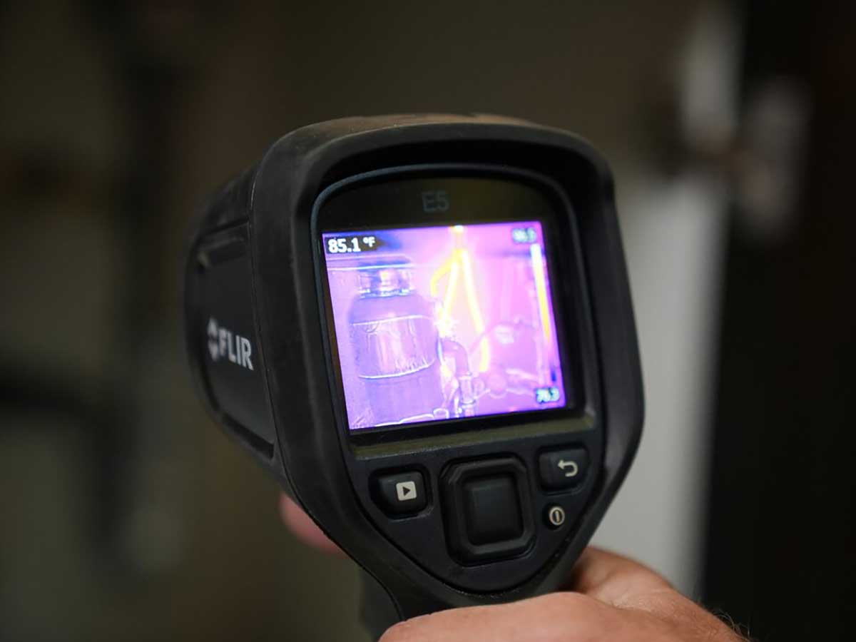 A closeup of a hand holding a FLIR device