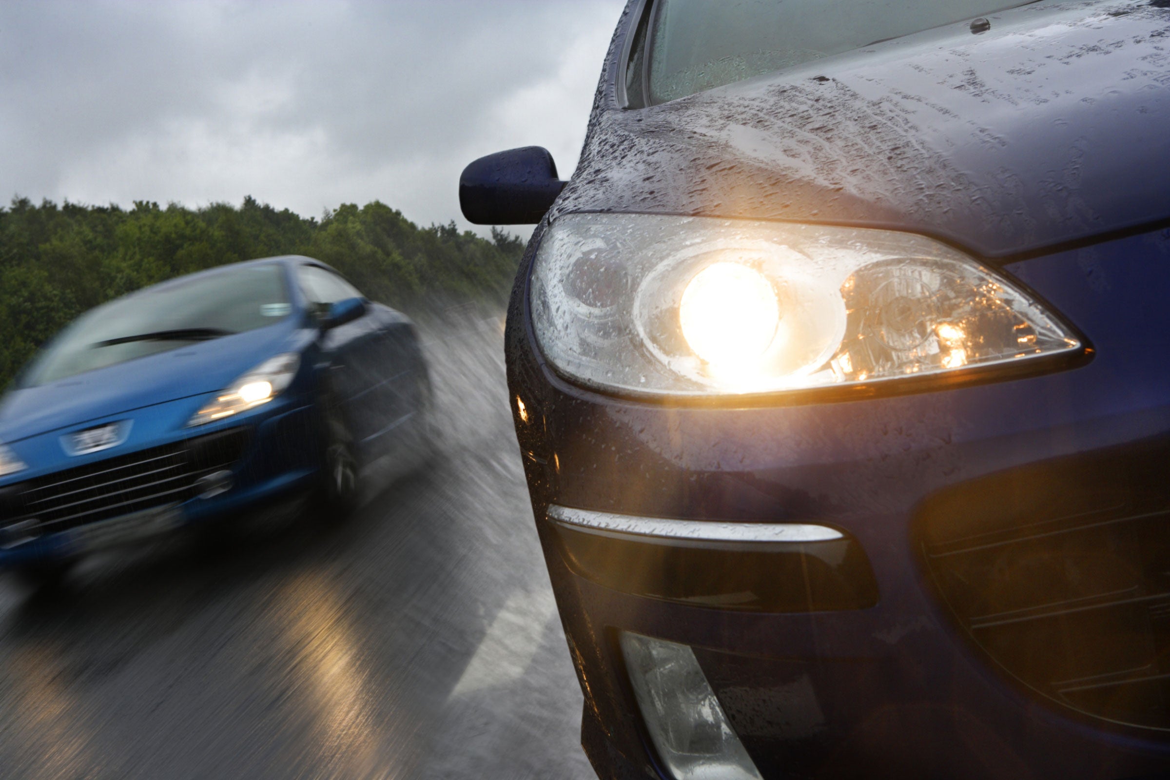 Two cars driving in the rain