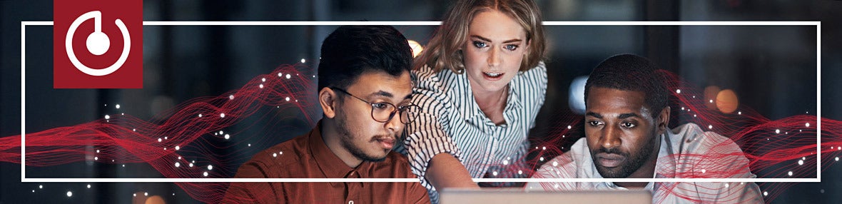 Three coworkers collaborating together in front of a laptop