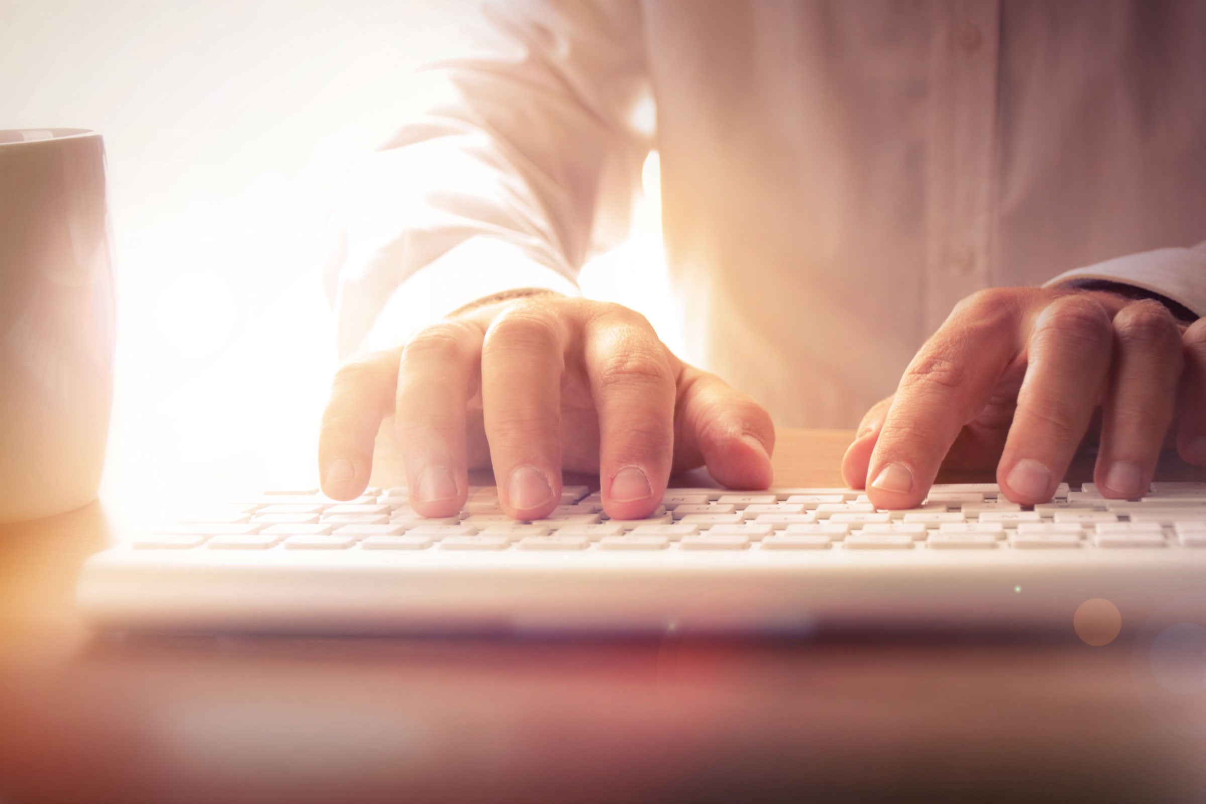 Closeup of hands typing on a computer keyboard