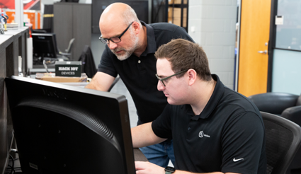 Two UL Solutions employees looking at a computer monitor