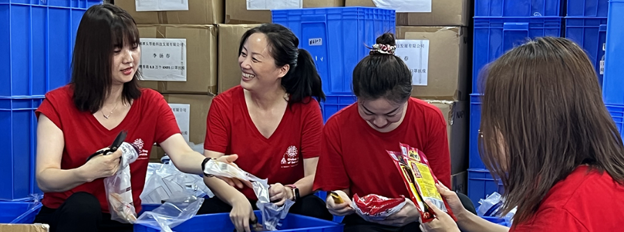 Four people working together to fill boxes for charity