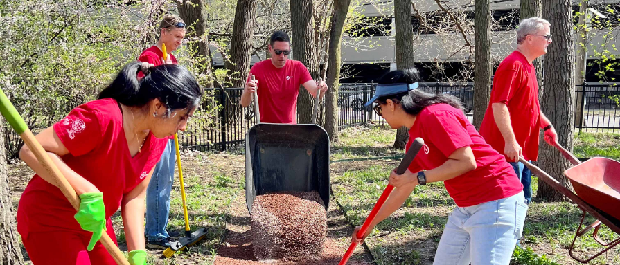 UL Solutions employees spreading mulch from a wheelbarrow