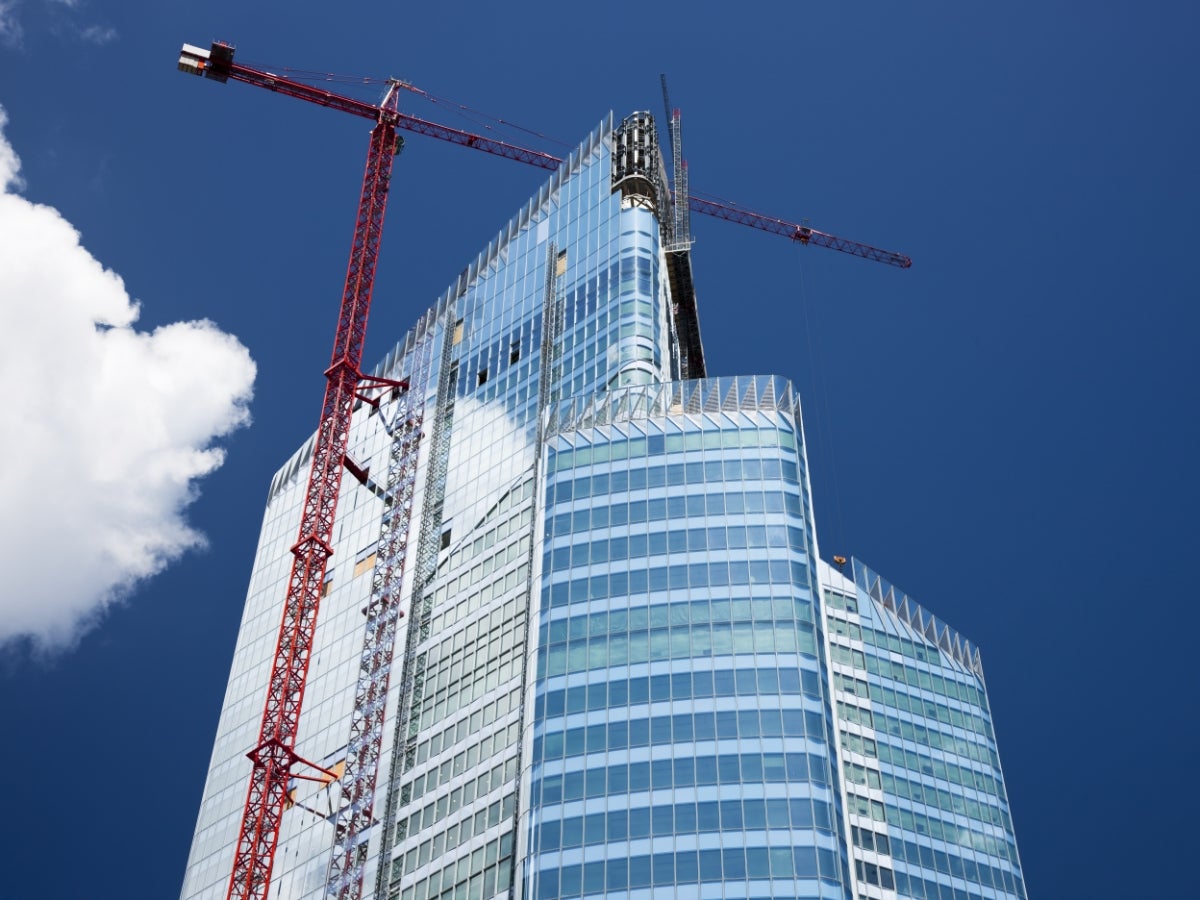 Upward view of a crane building a skyscraper