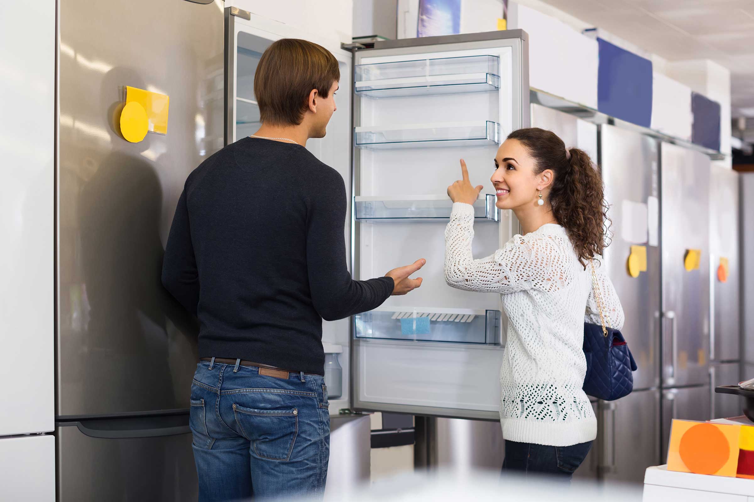 A couple shopping for a new refrigerator in a store