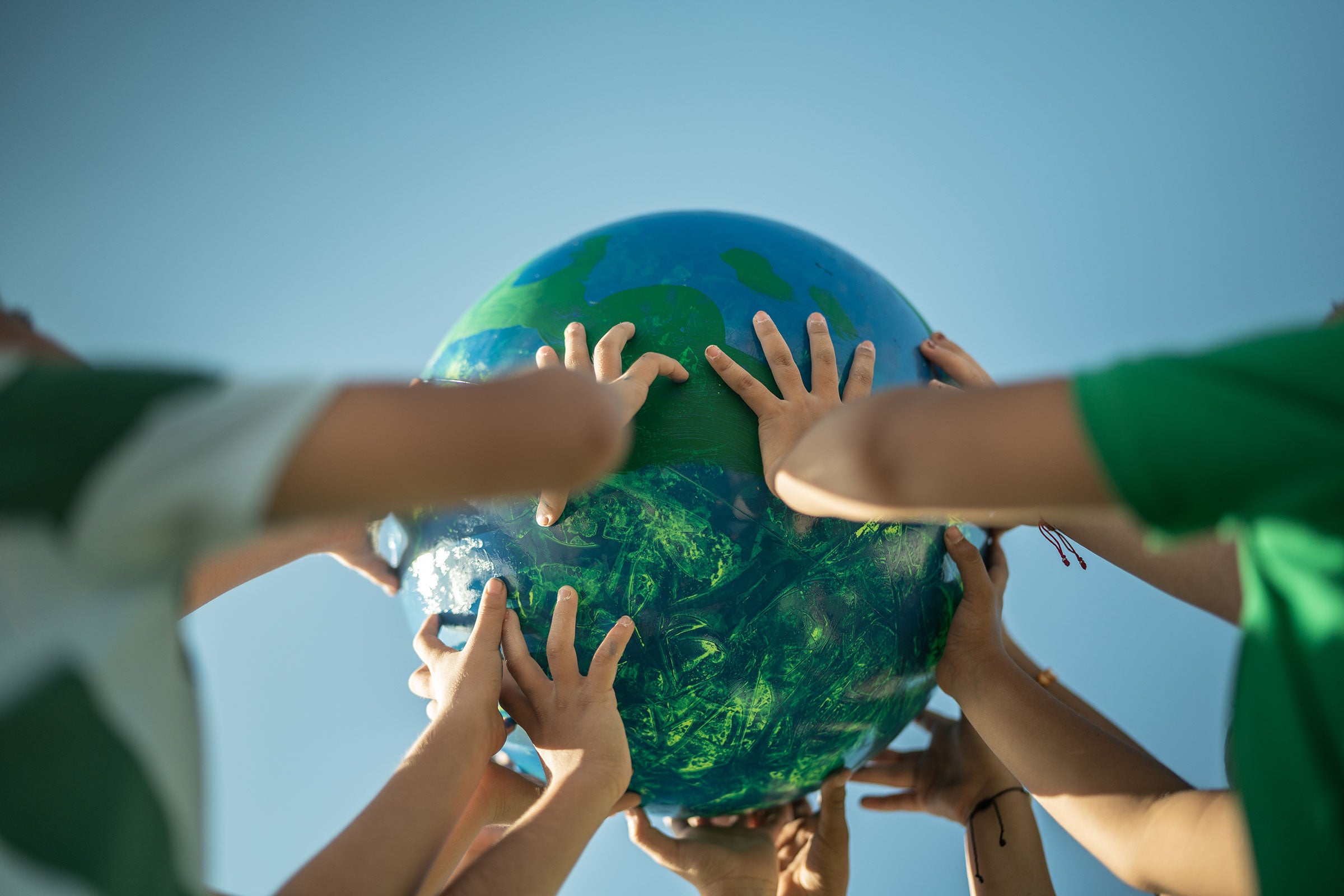 Children holding a planet outdoors