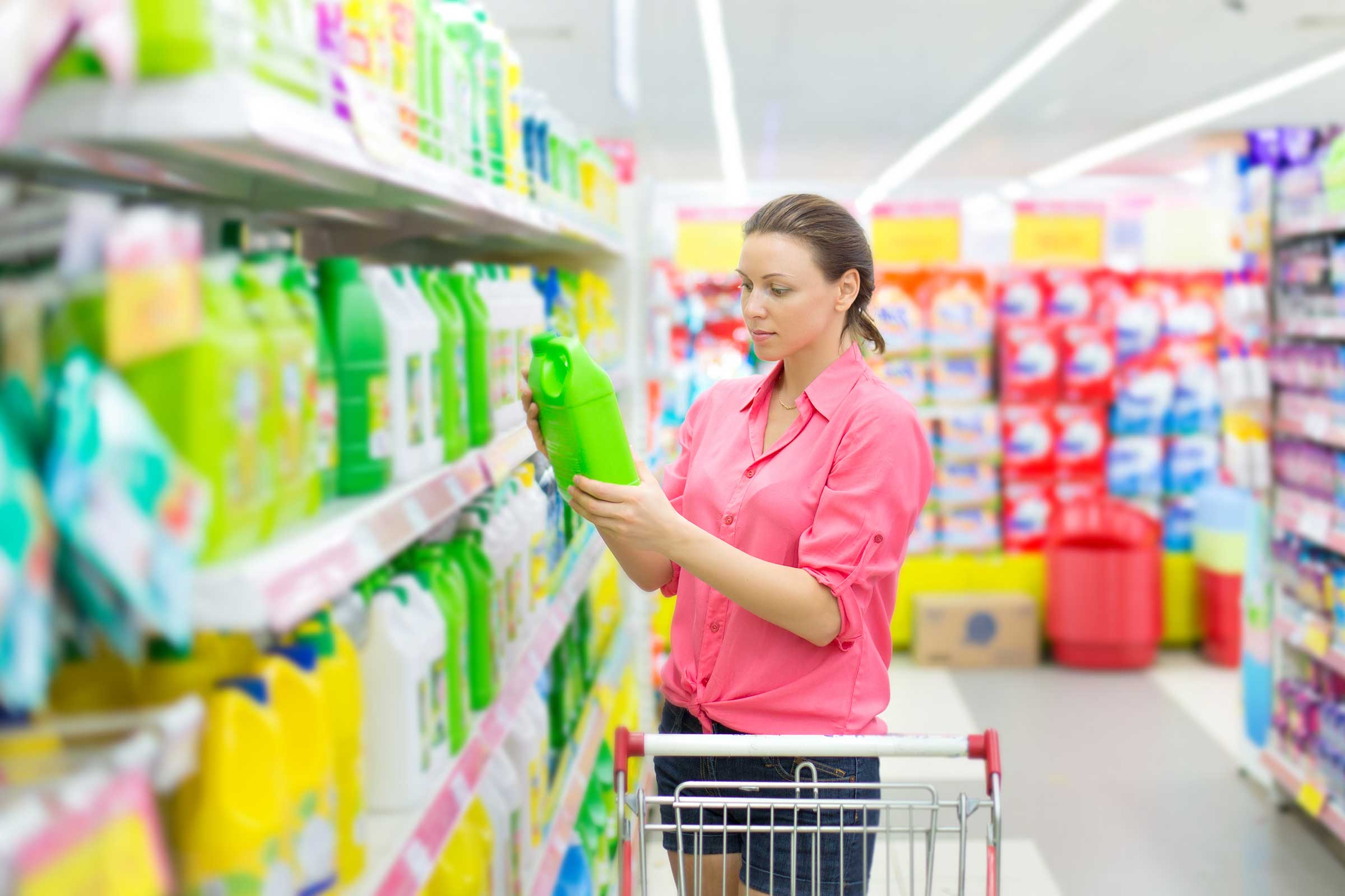 Person reading a label on a product while shopping in a store