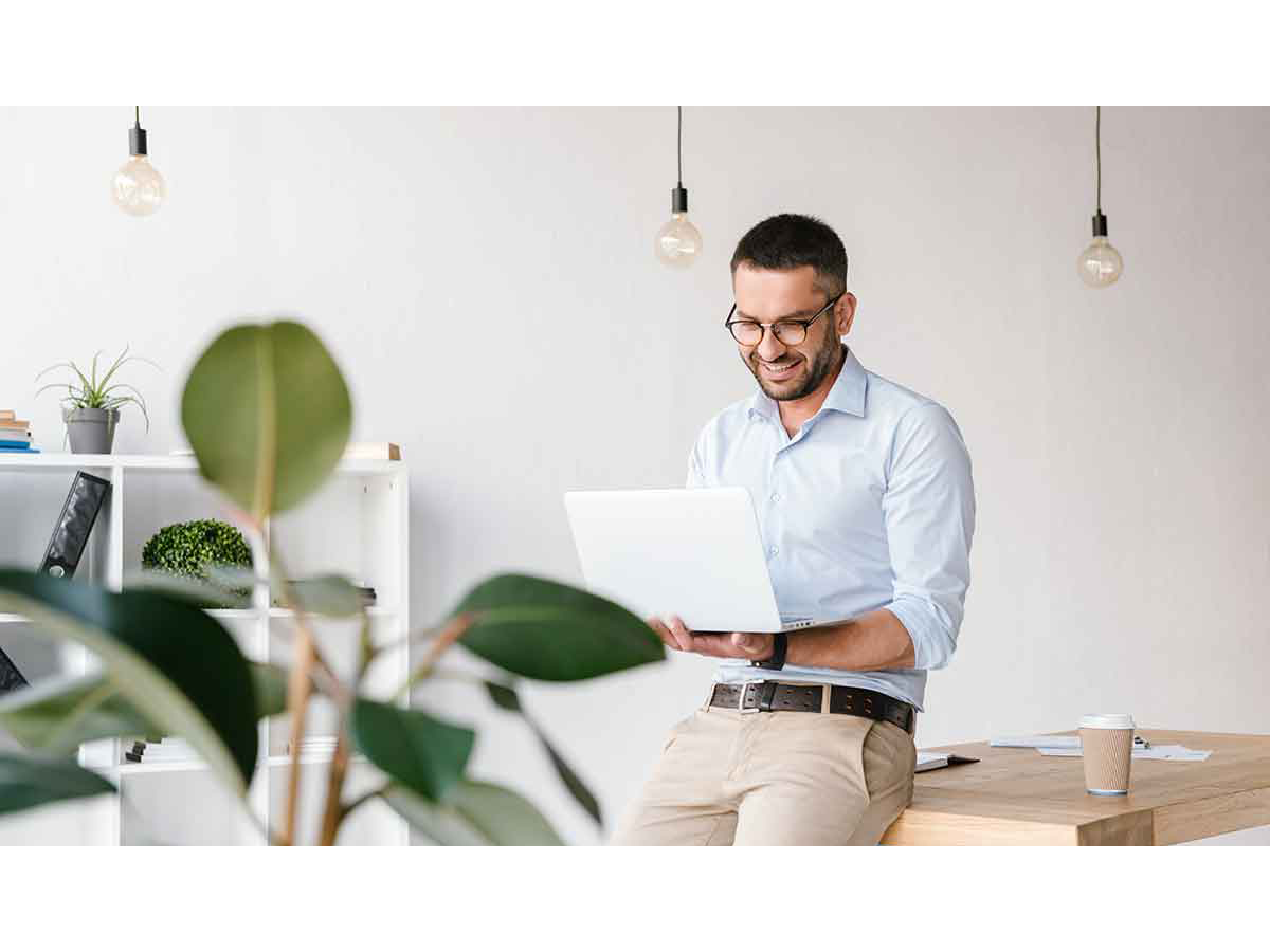 Person leaning on a table while using a laptop