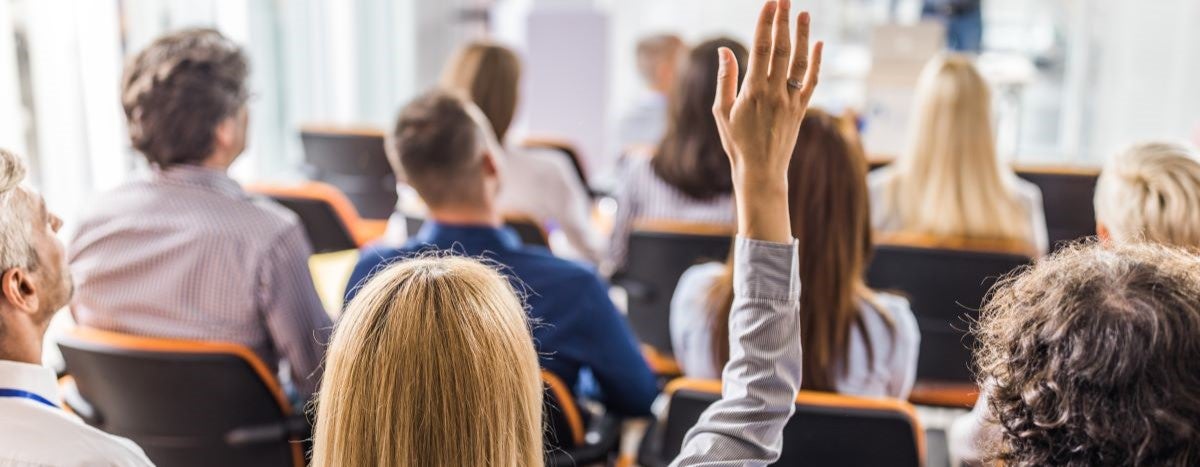 Back view of businesswoman raising arm on a training class in board room.