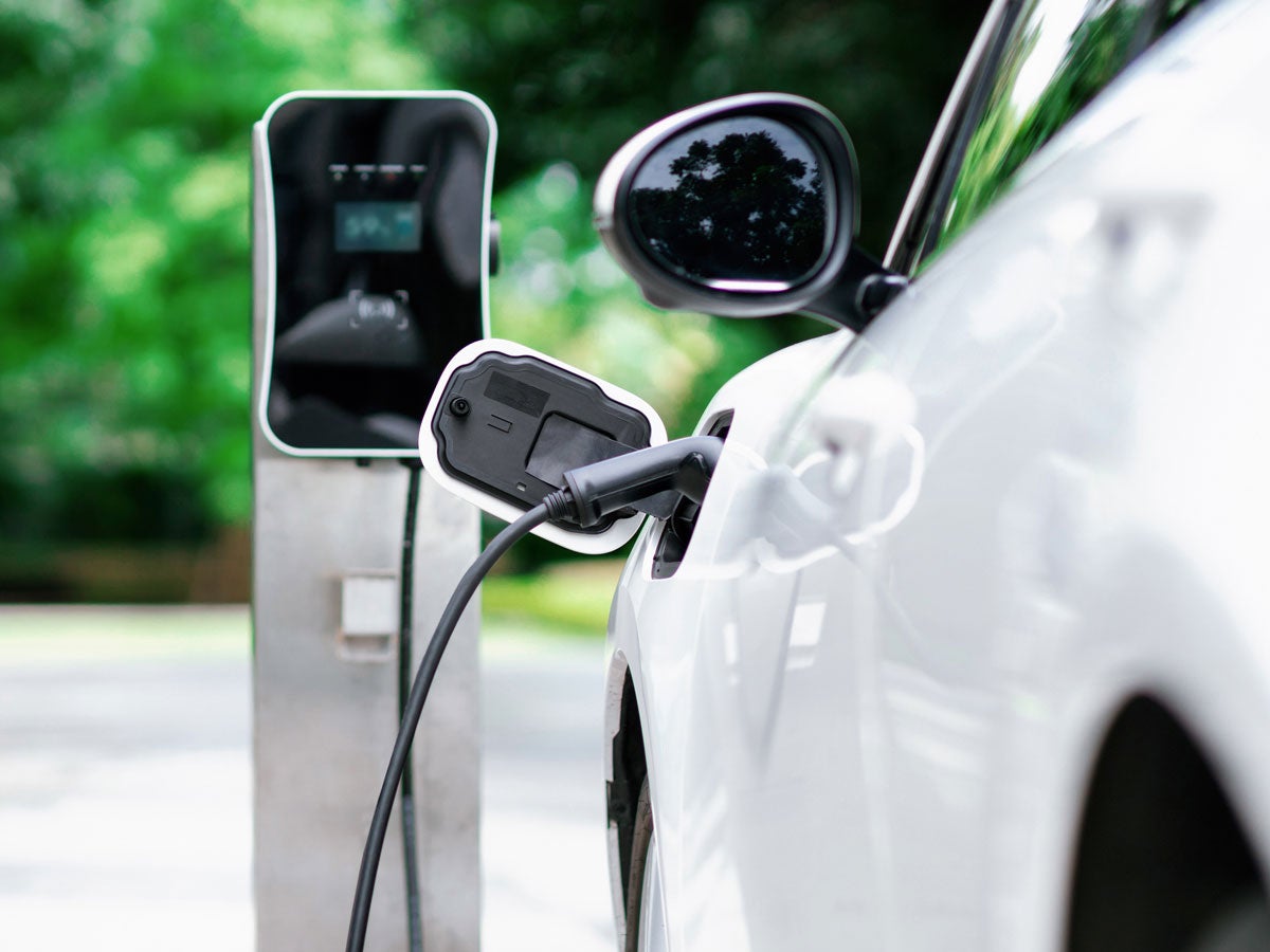 A white electric vehicle charging at a station