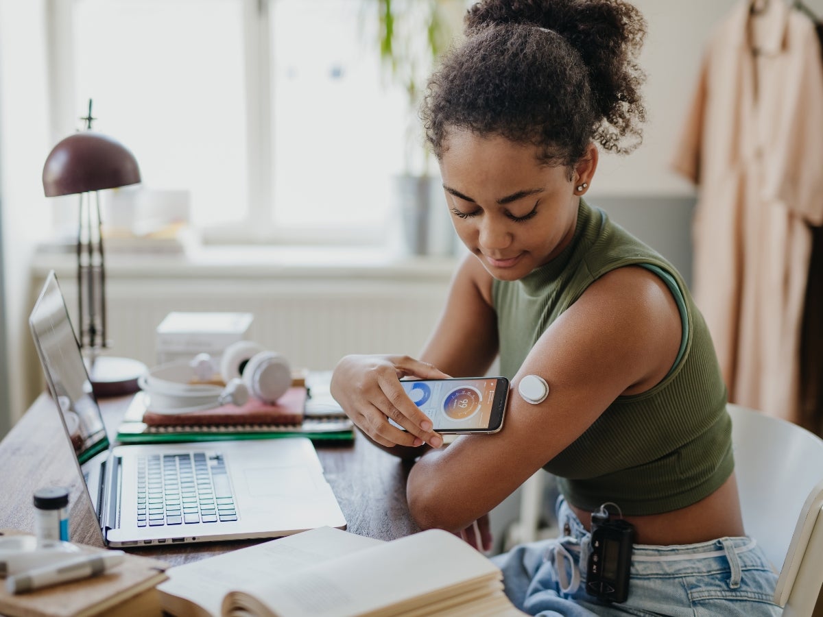 girl checking medical device on her phone