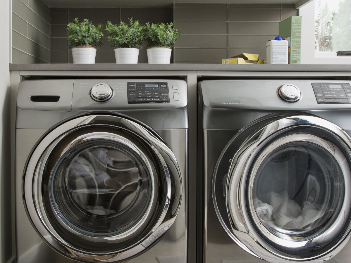 Silver washer and dryer set in a laundry room