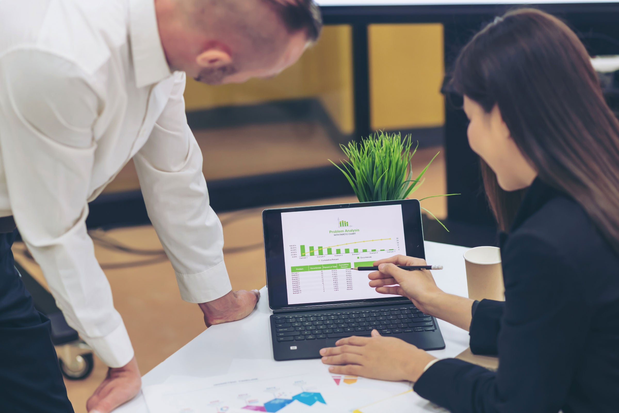 Two people looking at data on a monitor