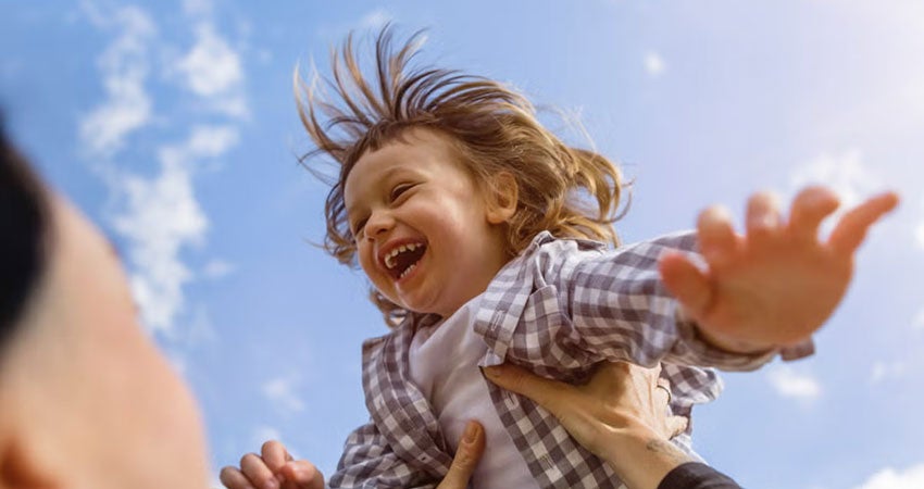 A child being playfully tossed into the air