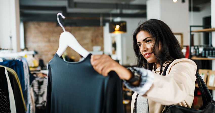 A person looking at a blouse on a hanger