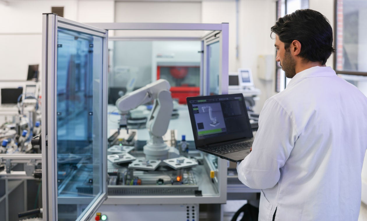 Engineer working on programming a robotic arm in a lab