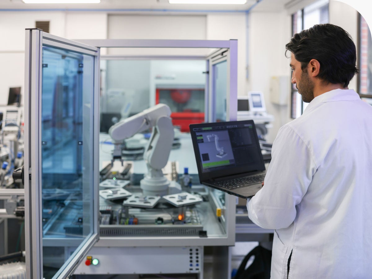 Engineer working on programming a robotic arm on a lab