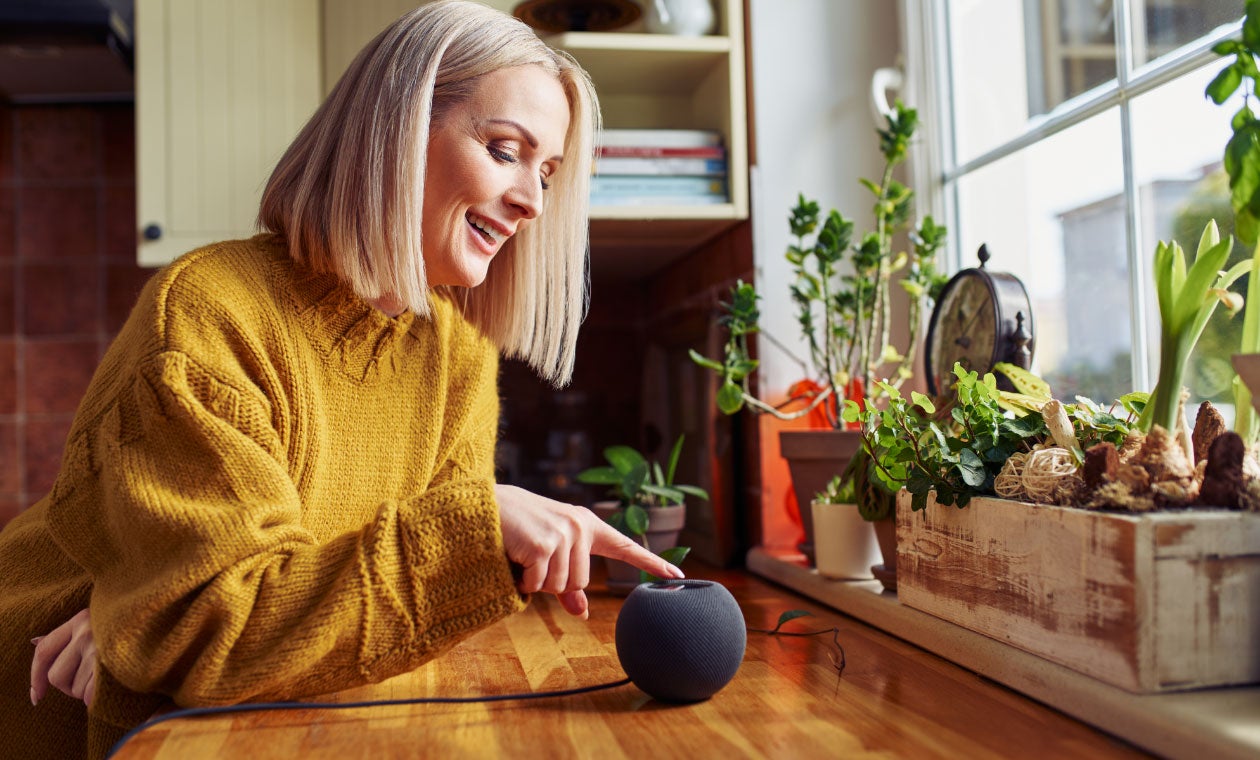 Person using a smart speaker in a kitchen