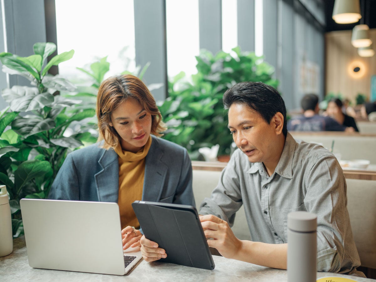 Two business colleagues collaborating over a tablet and tablet