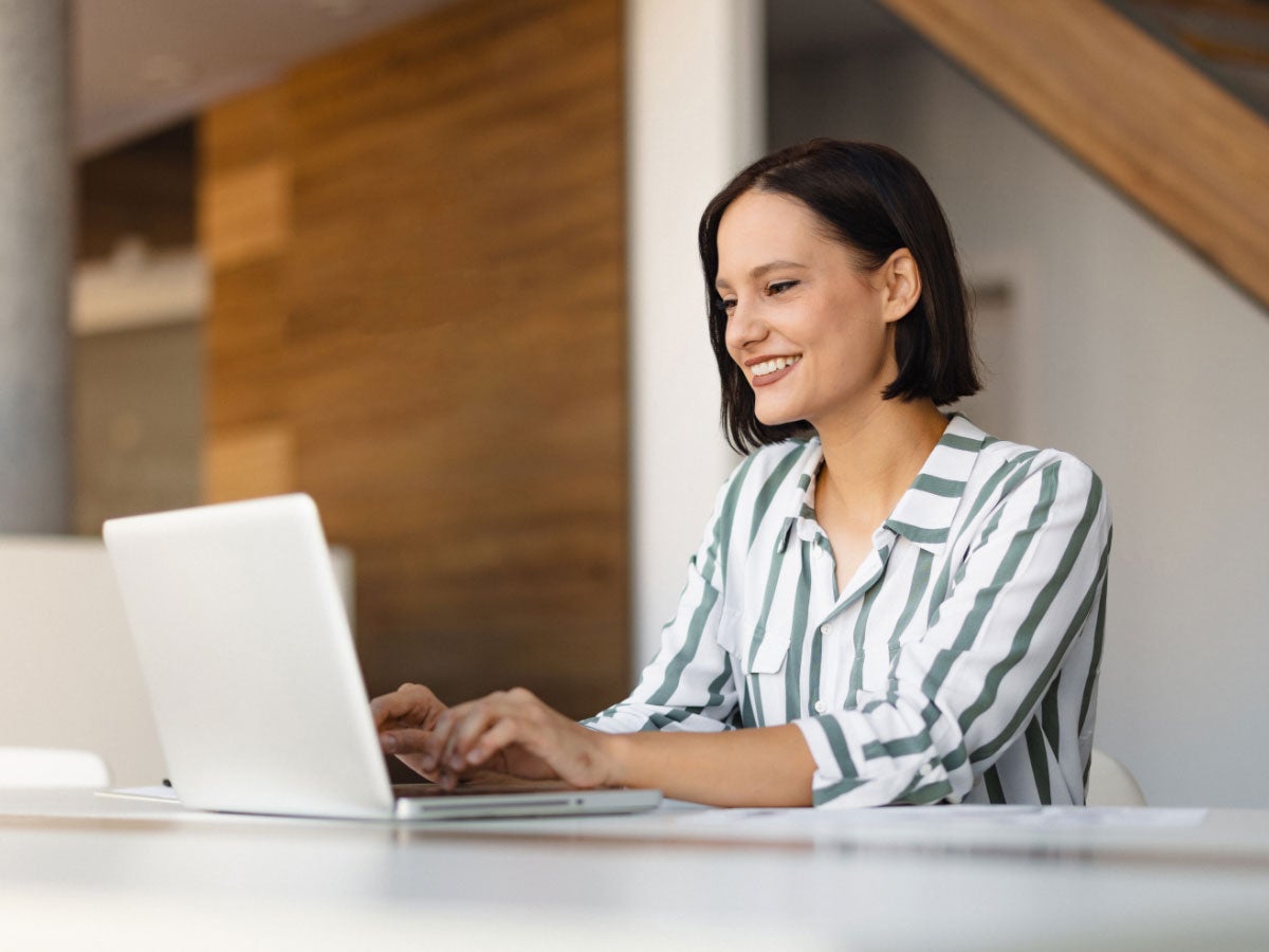 Person in a striped shirt using a laptop