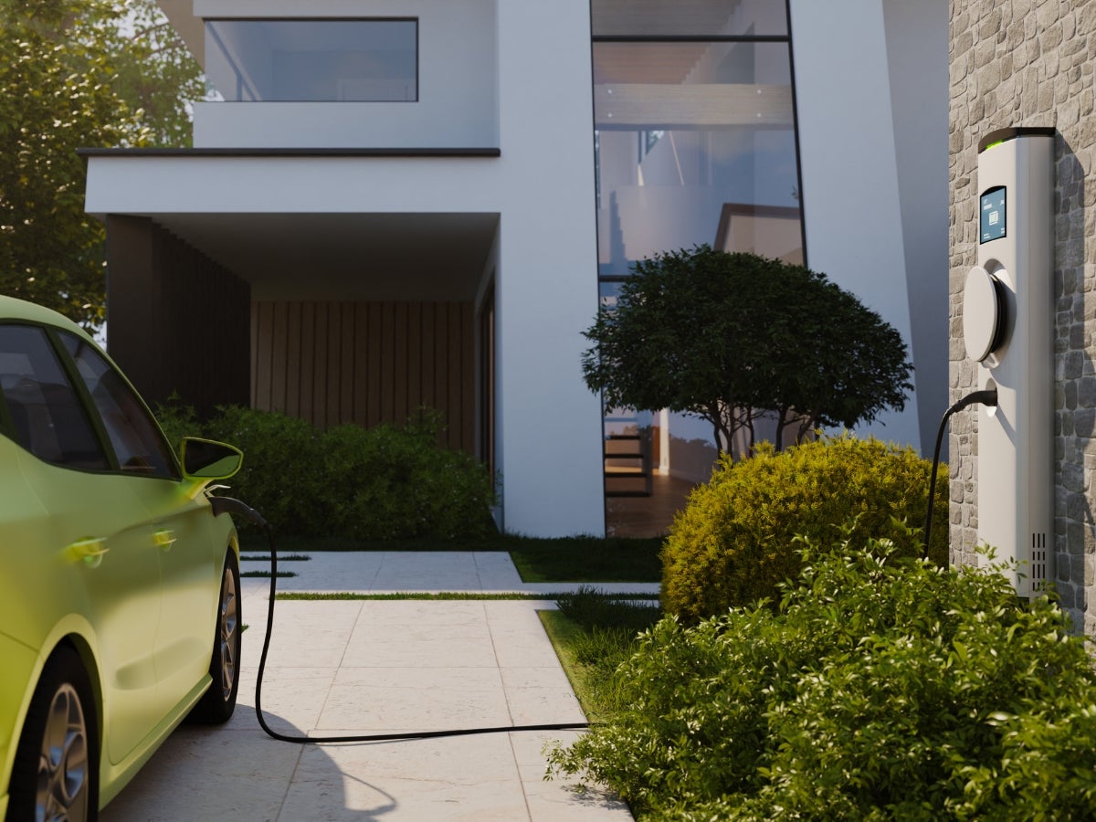 electric car charging in driveway of single family home