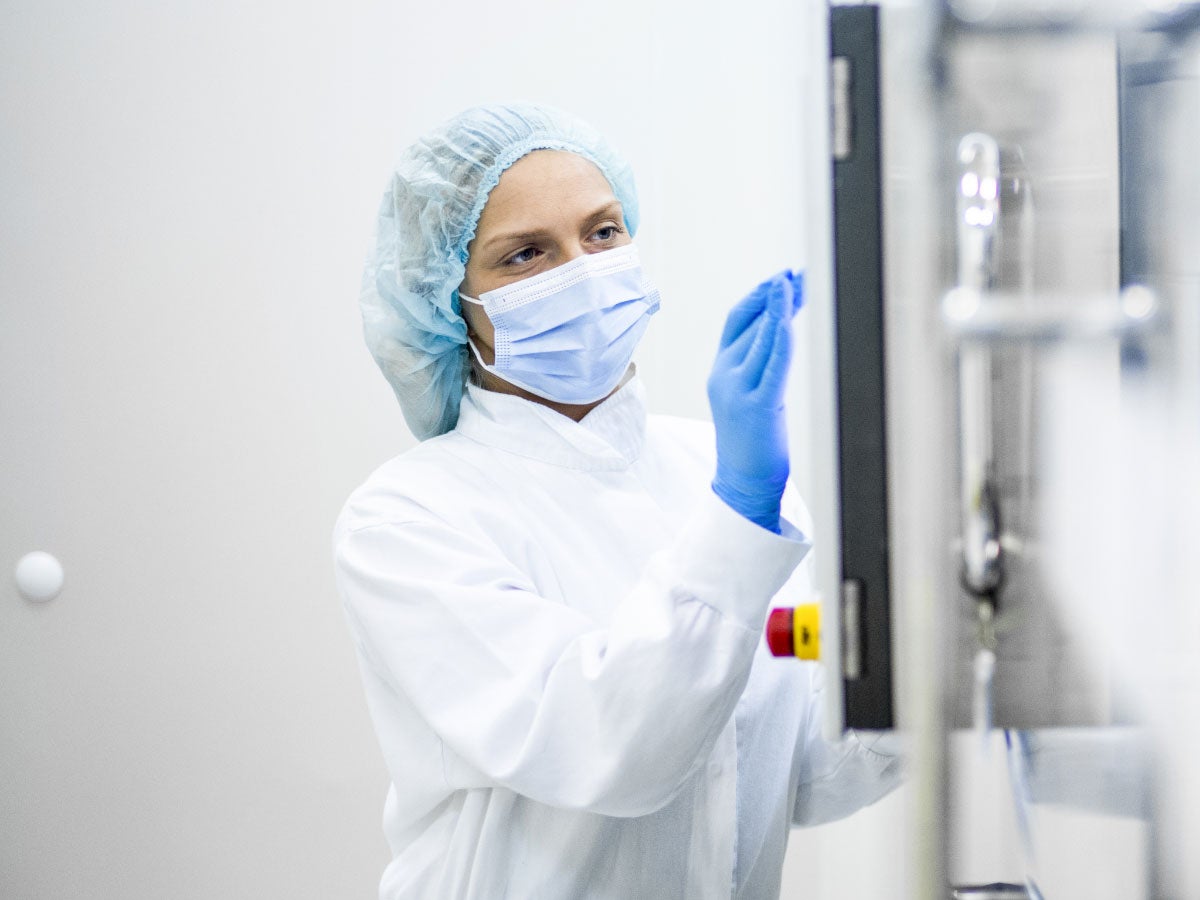 Lab scientist taping on the screen of a pharmaceutical machine