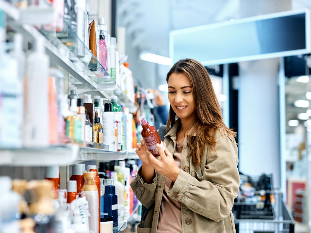 Shopper reading ingredients of skin care product while at the store
