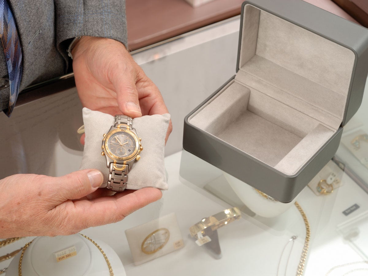 Salesperson showing a luxury wristwatch in a jewelry store. 