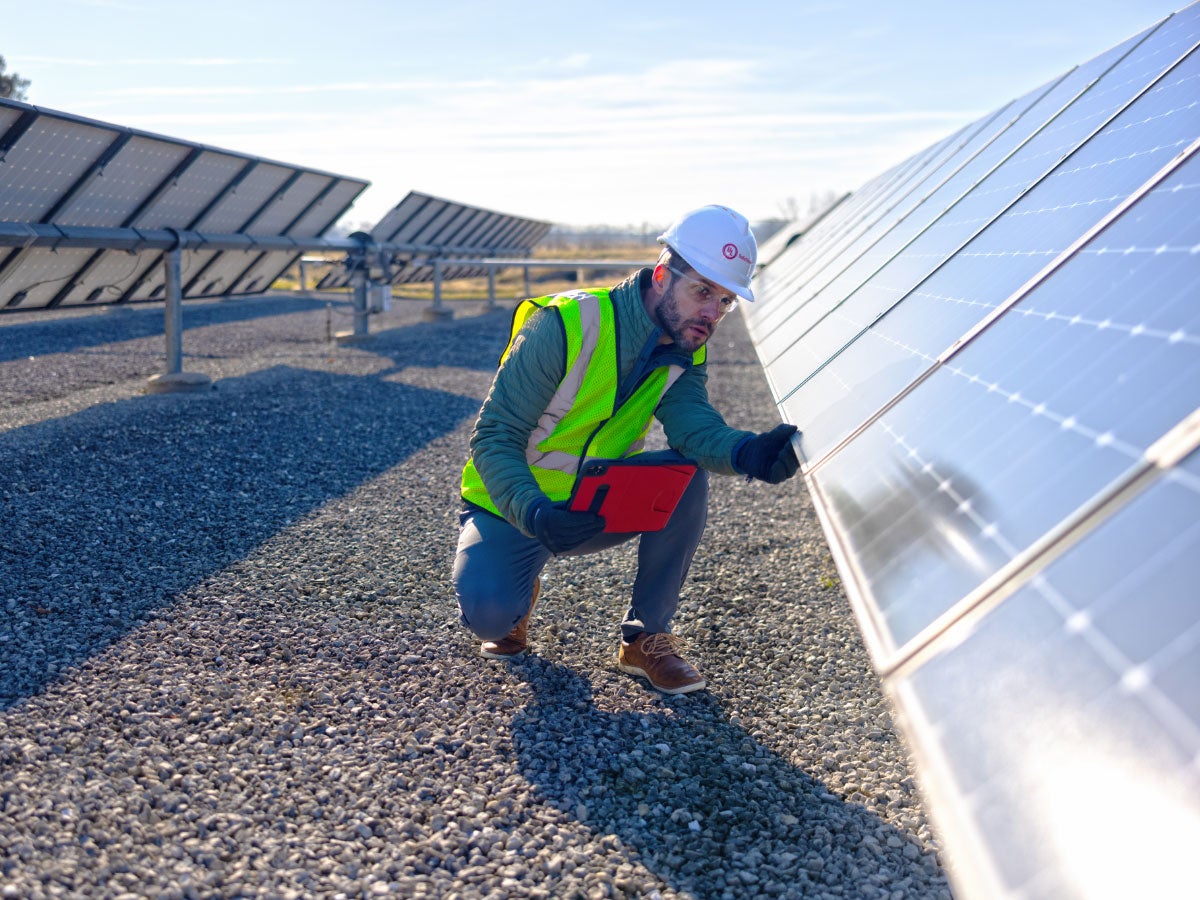 UL Solution field inspector looking at solar panels at a solar farm