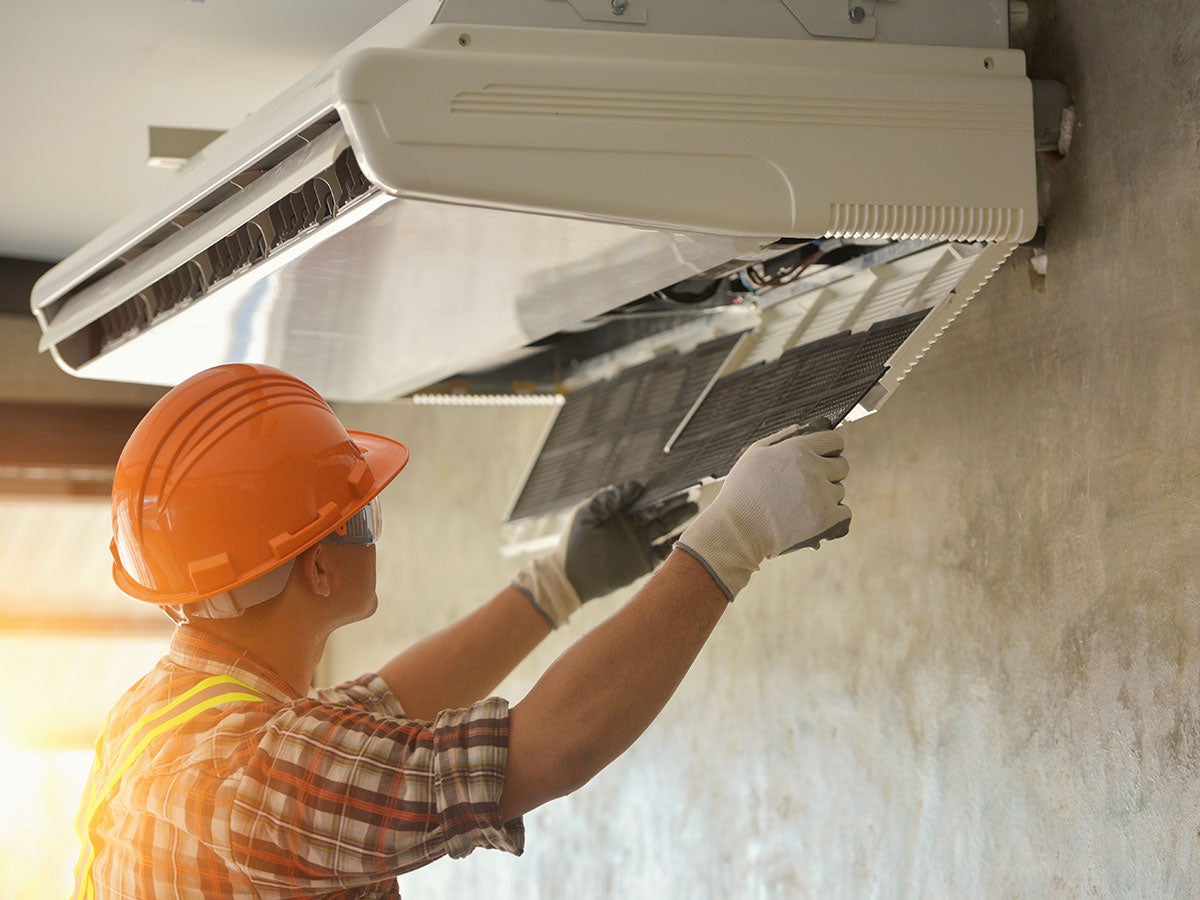A person working on an HVAC unit