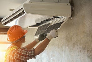 A person working on an HVAC unit