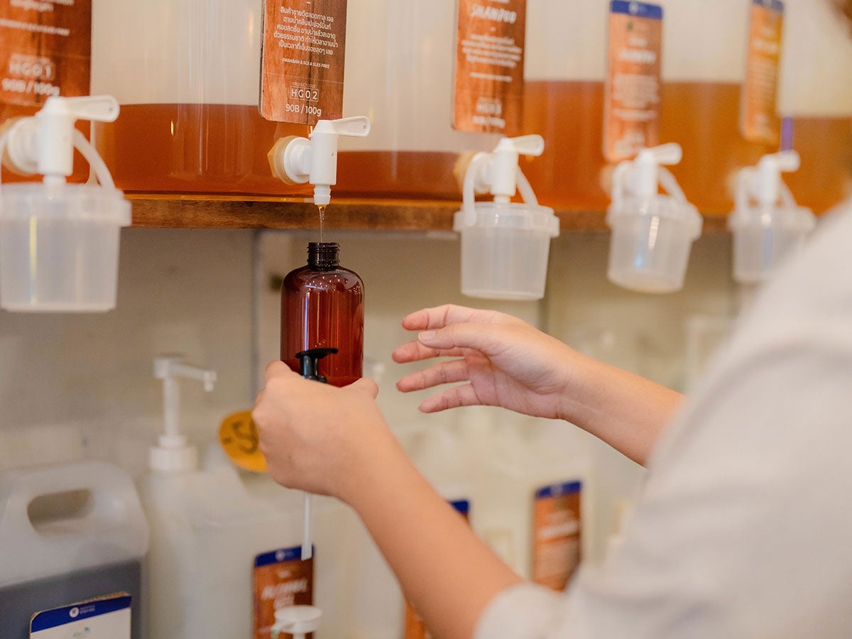A person filling a bottle with a beauty product