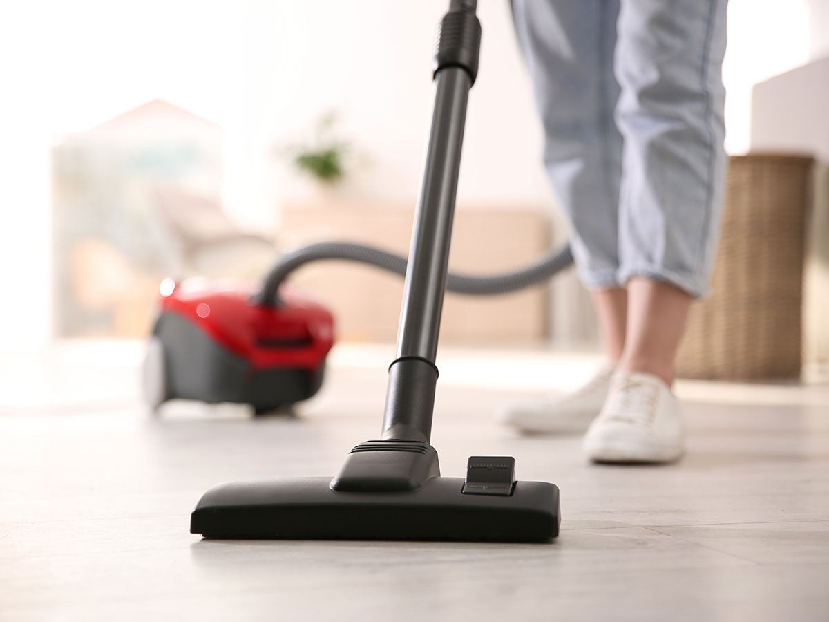 A person using a small vacuum cleaner
