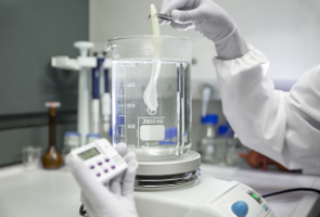 a person working in a lab and measuring a liquid