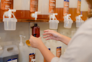 A person pouring beauty products into another container