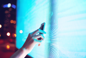 A person scanning a monitor with a mobile device